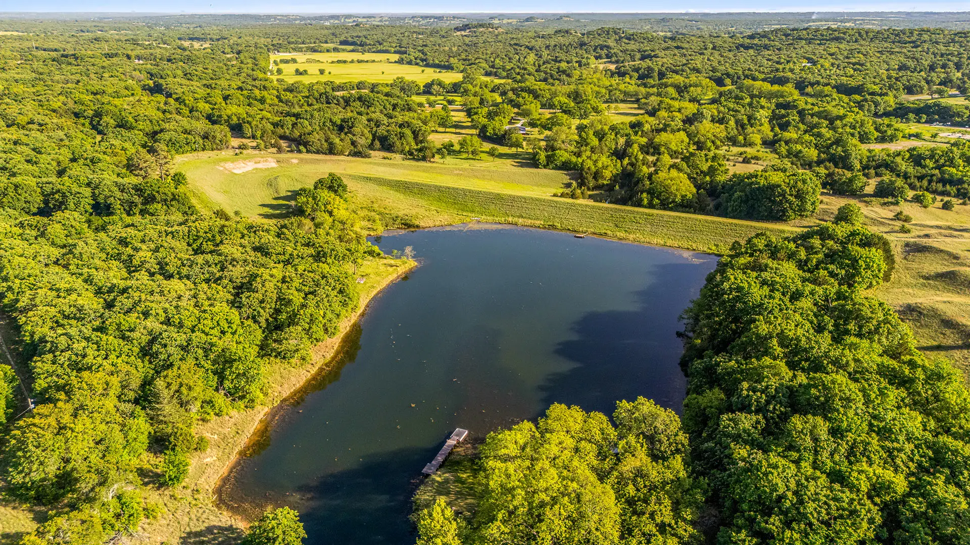 Aerial view of a seasonal creek winding through timber at The Vistas at Clear Creek